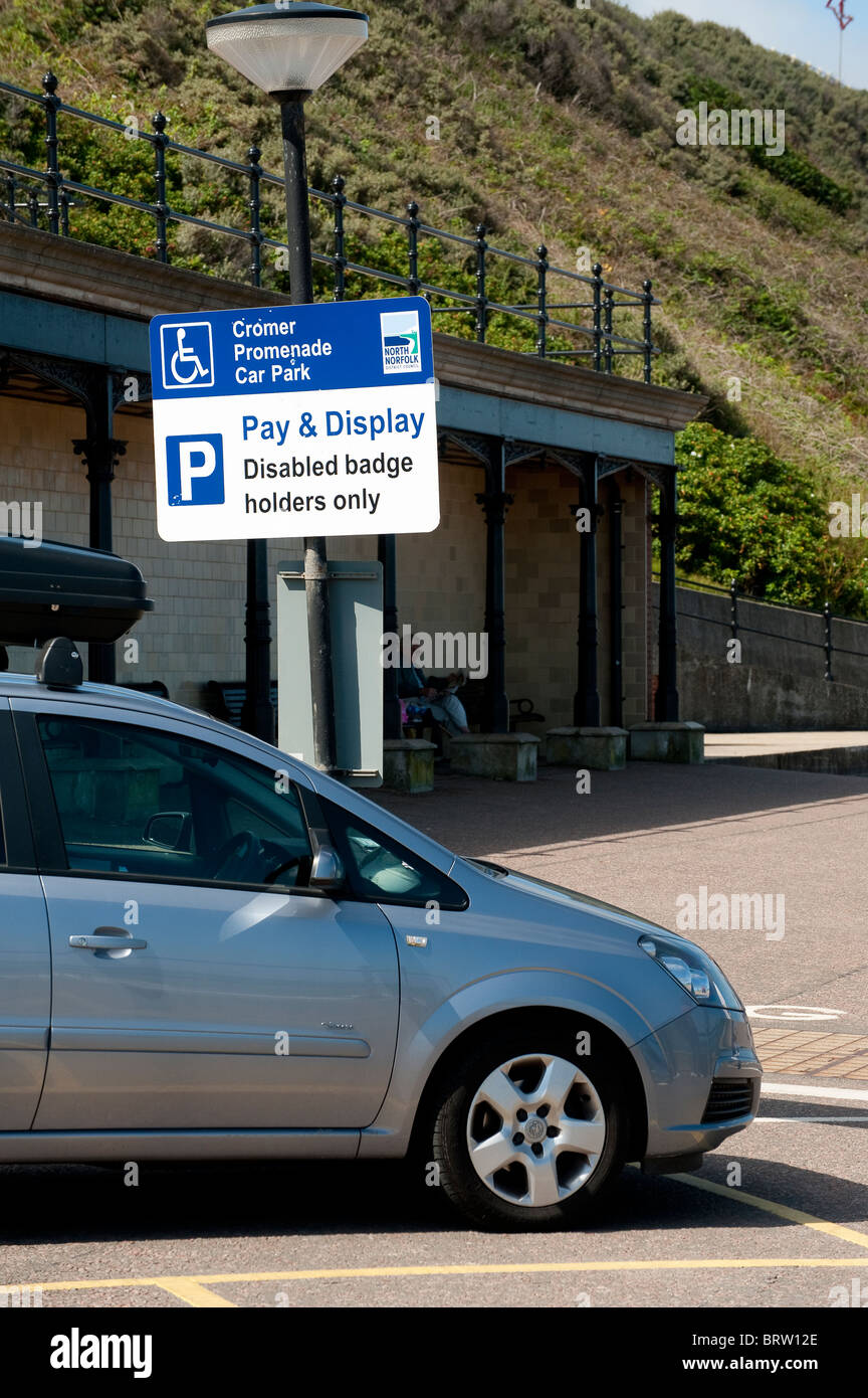 Macchina parcheggiata in un badge disabili titolari bay presso un parcheggio auto a pagamento a Cromer, Norfolk, Inghilterra Foto Stock
