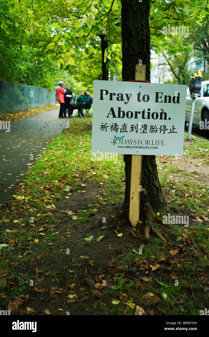 Anti-aborto segno e manifestanti sul viale alberato di marciapiede. Foto Stock