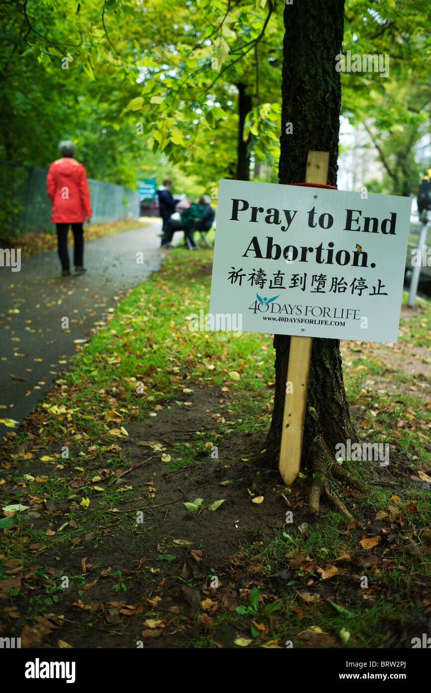Anti-aborto segno e manifestanti sul viale alberato di marciapiede. Foto Stock