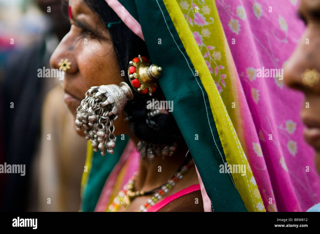 Una coloratissima donna indiana indossando il tradizionale grande orecchini in argento. Foto Stock