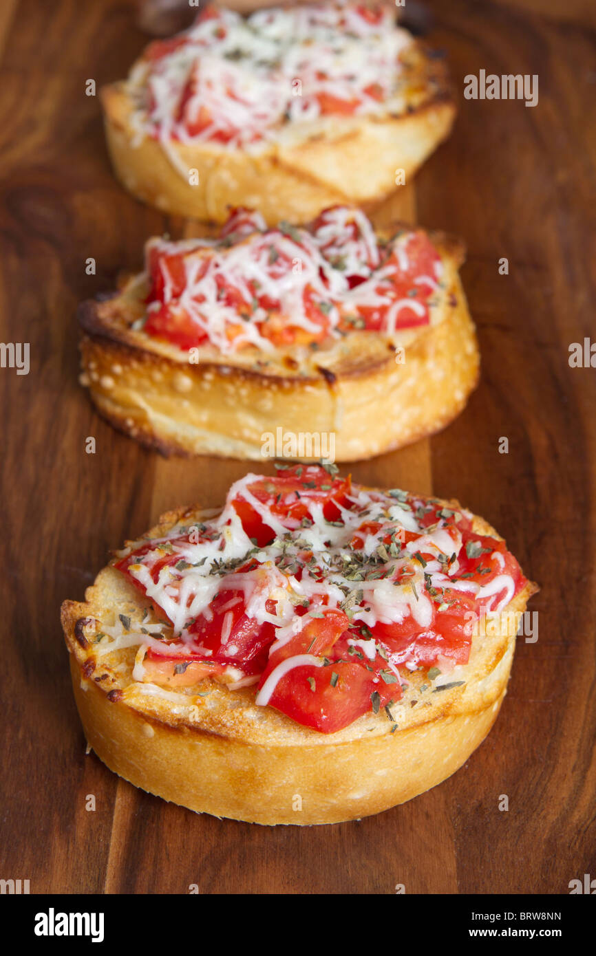 Tre piccoli morsi bruschetta su un tagliere Foto Stock