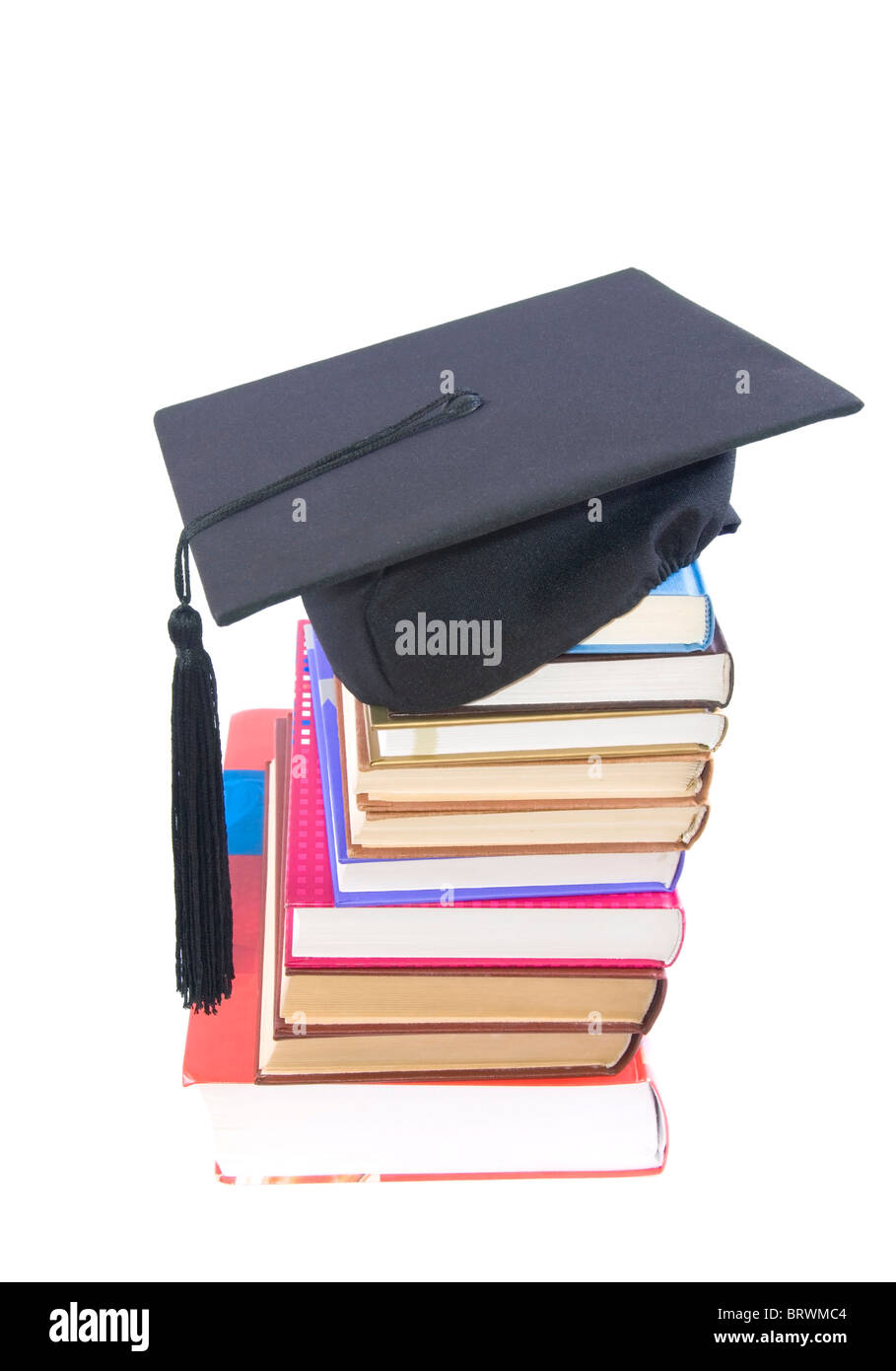 Student hat su una torre fatta di libri, contro uno sfondo bianco - concetto di istruzione Foto Stock