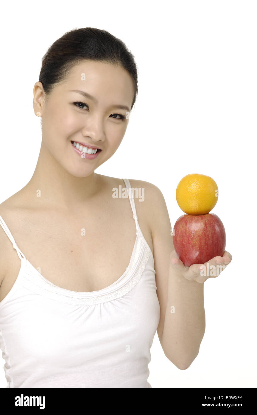 Bella asiatica ritratto femminile con la rappresentazione di frutta - isolato Foto Stock
