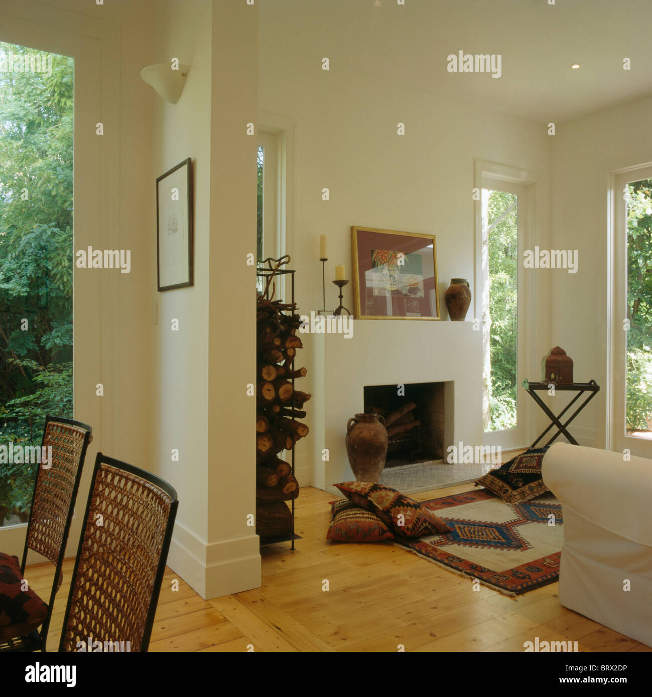 Cuscini e tappeto di fronte al caminetto in bianco moderno salotto a pianta  aperta interno con pavimento in legno Foto stock - Alamy