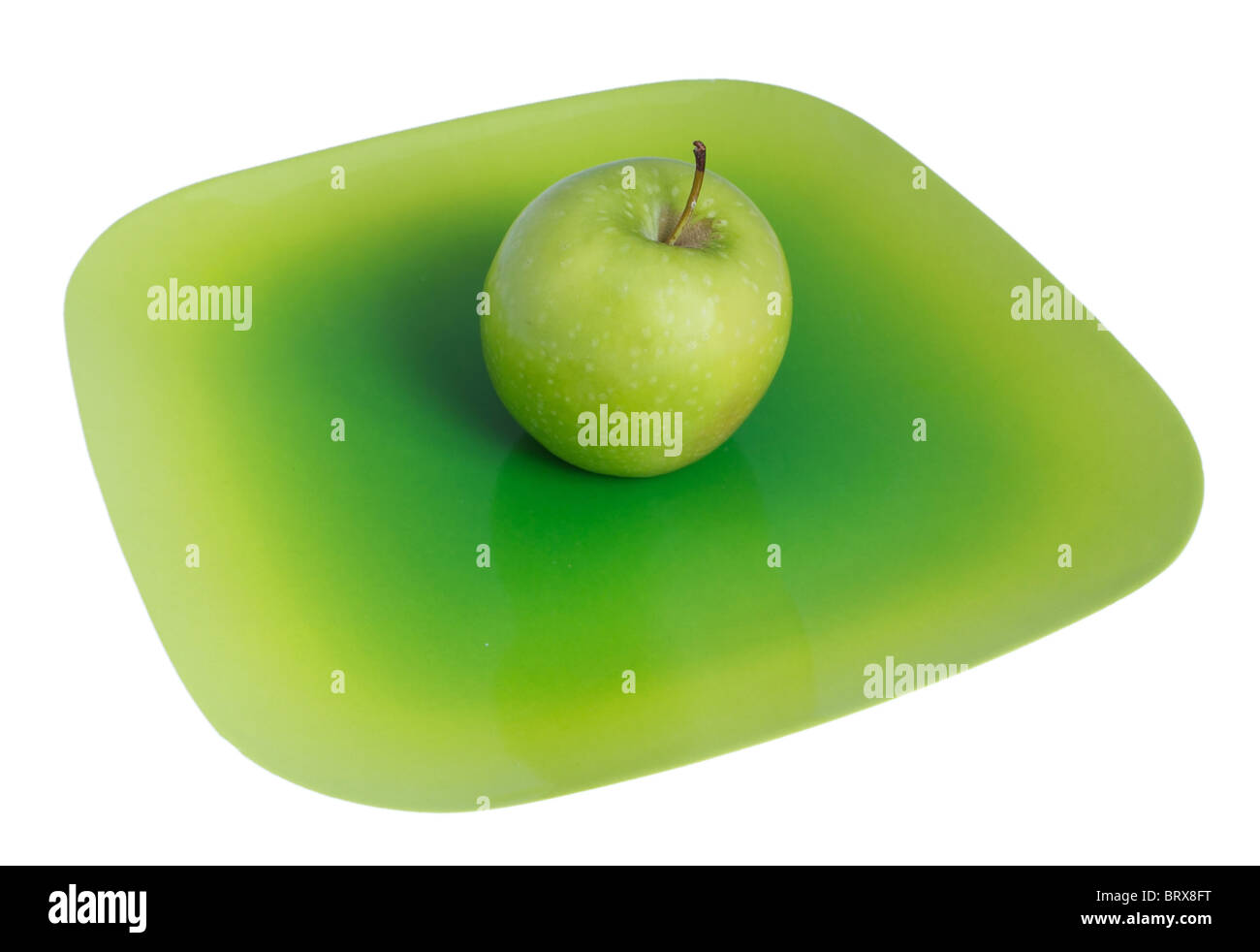 Verde mela su una piastra isolata su bianco Foto Stock