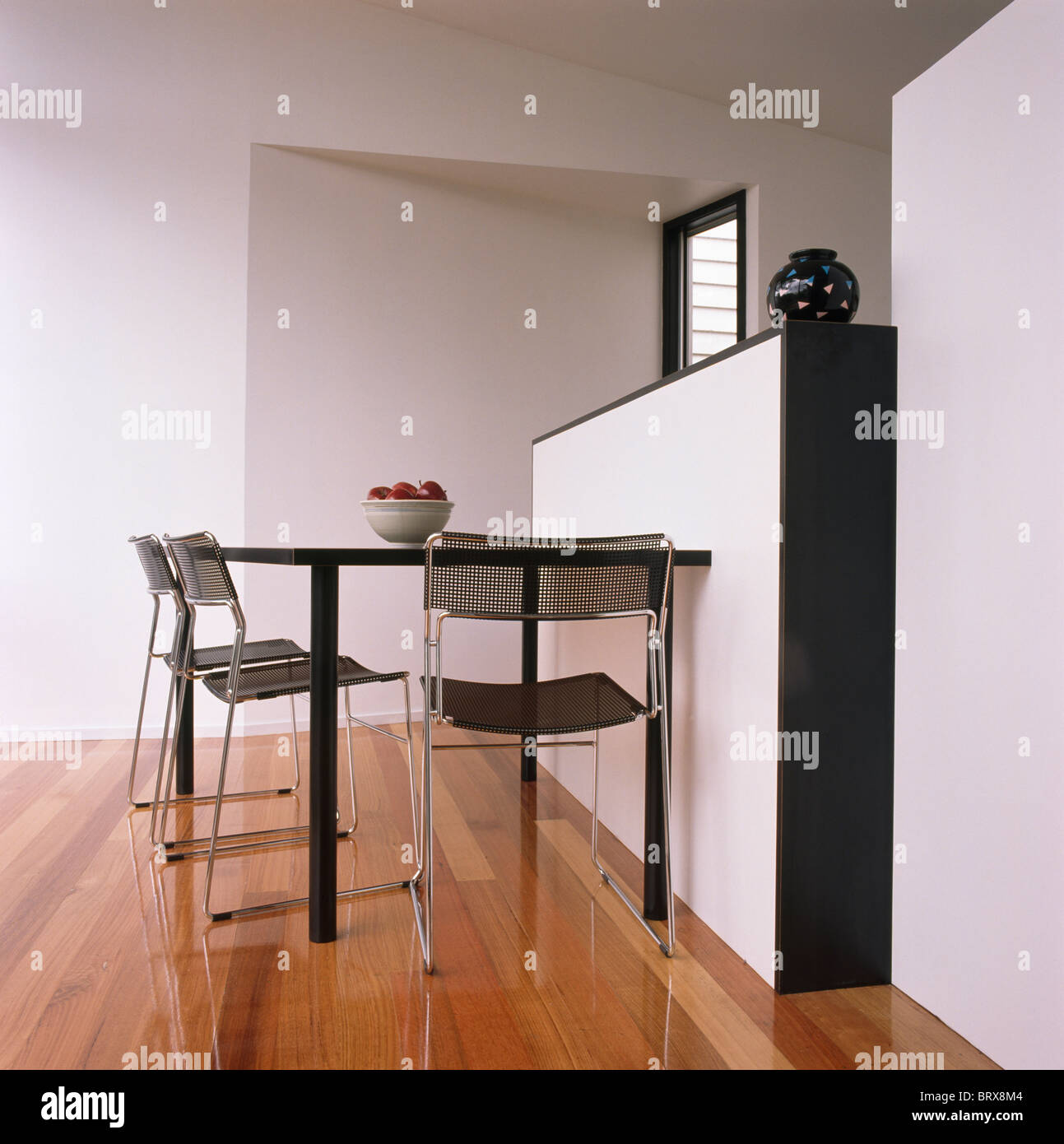 Nero piccolo tavolo e sedie in bianca e moderna sala da pranzo con parquet Foto Stock