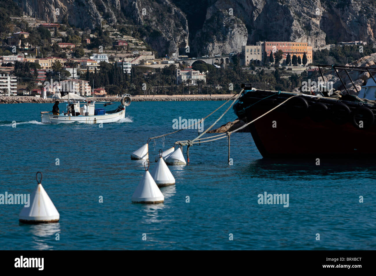 Barca da pesca lasciando la marina e yacht di lusso di fronte ALPES-MARITIMES (06), Francia Foto Stock