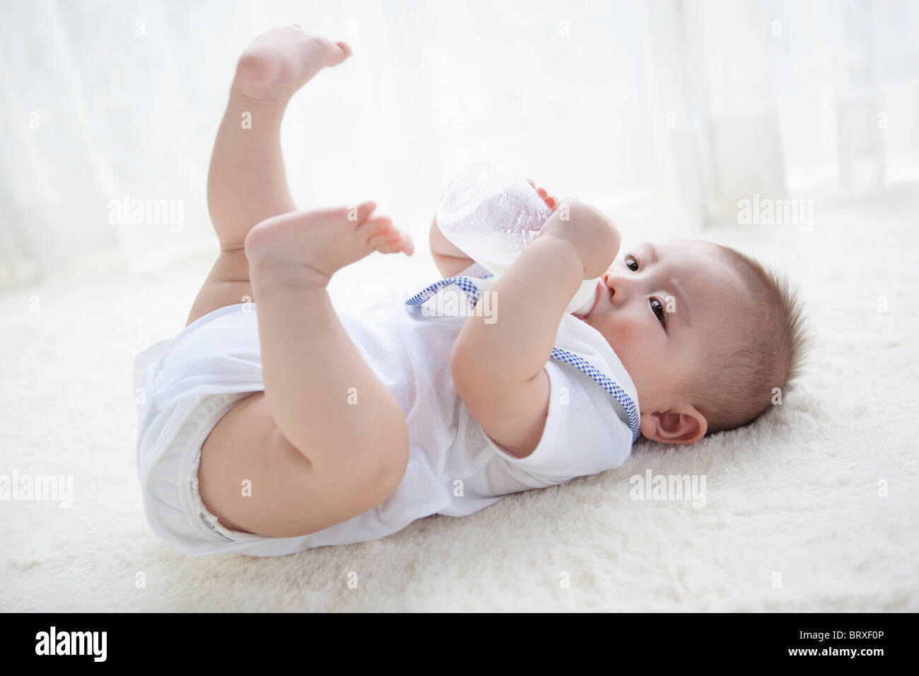 Baby Boy bere latte dalla bottiglia Foto Stock