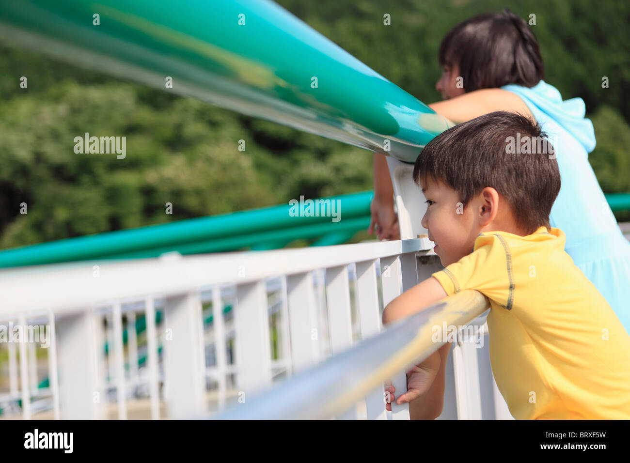 Un ragazzo e una ragazza guardando attraverso le ringhiere Foto Stock