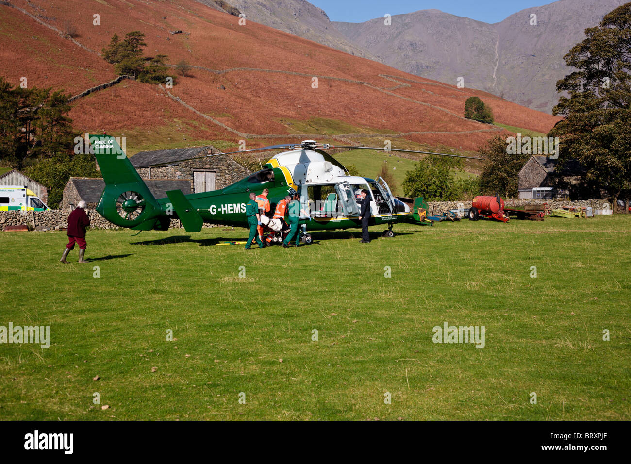 Grande Nord Air Ambulance, Cumbria. L'equipaggio e personale paramedico da un'ambulanza portano una signora anziana di attesa in elicottero. Foto Stock