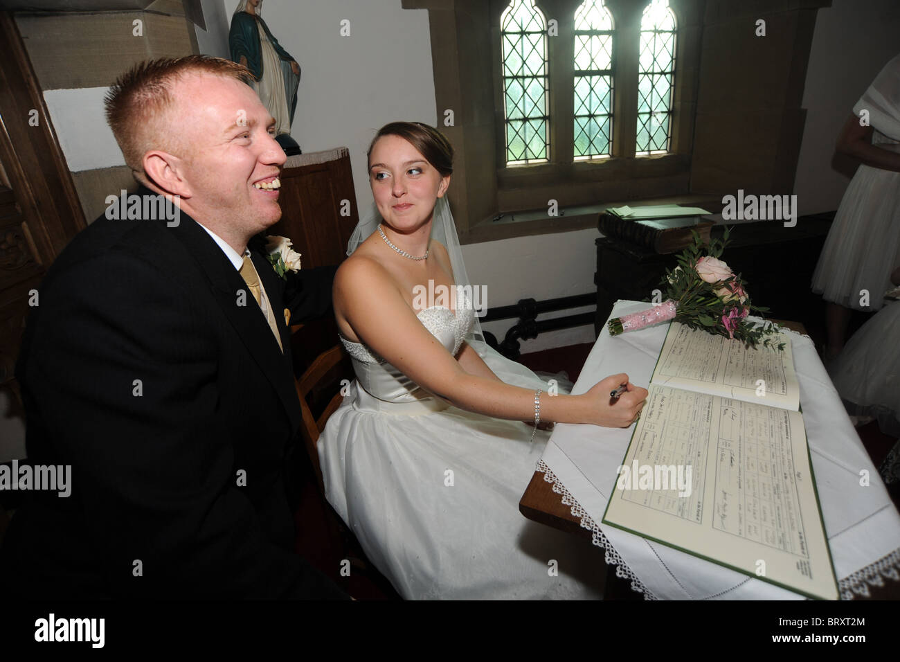 Sposa e lo sposo appena sposato firma il registro Foto Stock