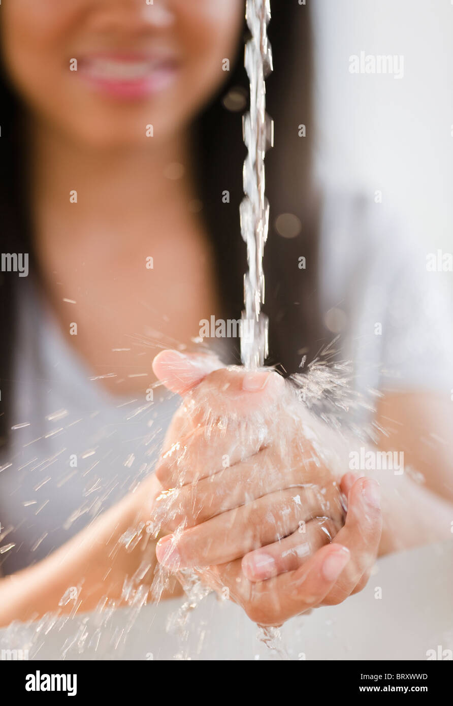 Close up di razza mista ragazza adolescente lavaggio delle mani in acqua Foto Stock