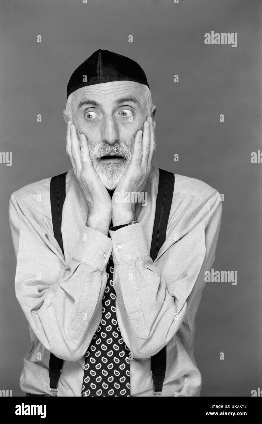 Anni Novanta ritratto uomo ebraico barba grigia che indossa YARMULKE entrambe le mani sulla faccia espressione divertente OY MOLTO TIMORE DI SHOCK PREOCCUPARSI DELLA DISPERAZIONE Foto Stock