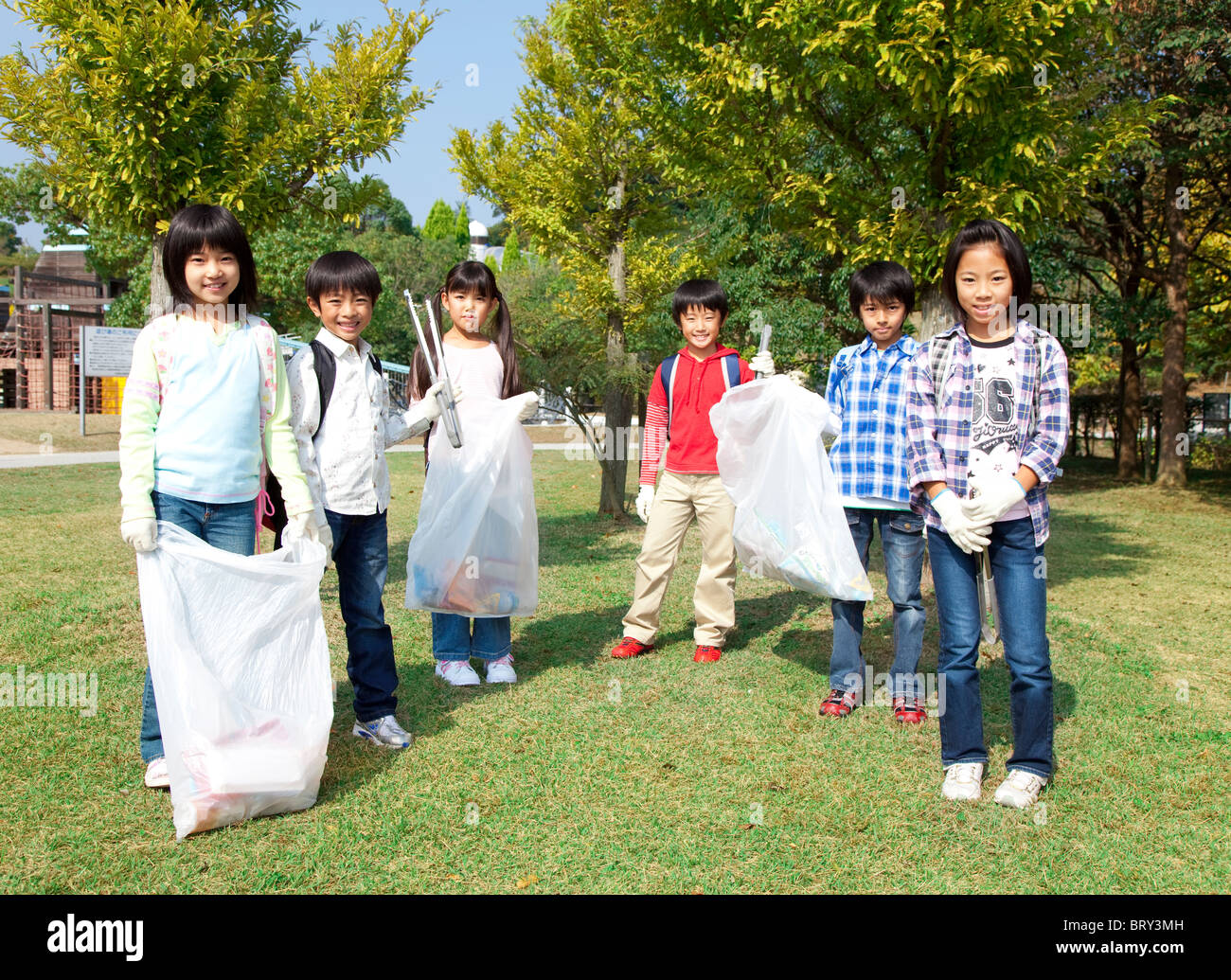 Ritratto di bambini della scuola di sacchetti di contenimento per il riciclaggio Foto Stock