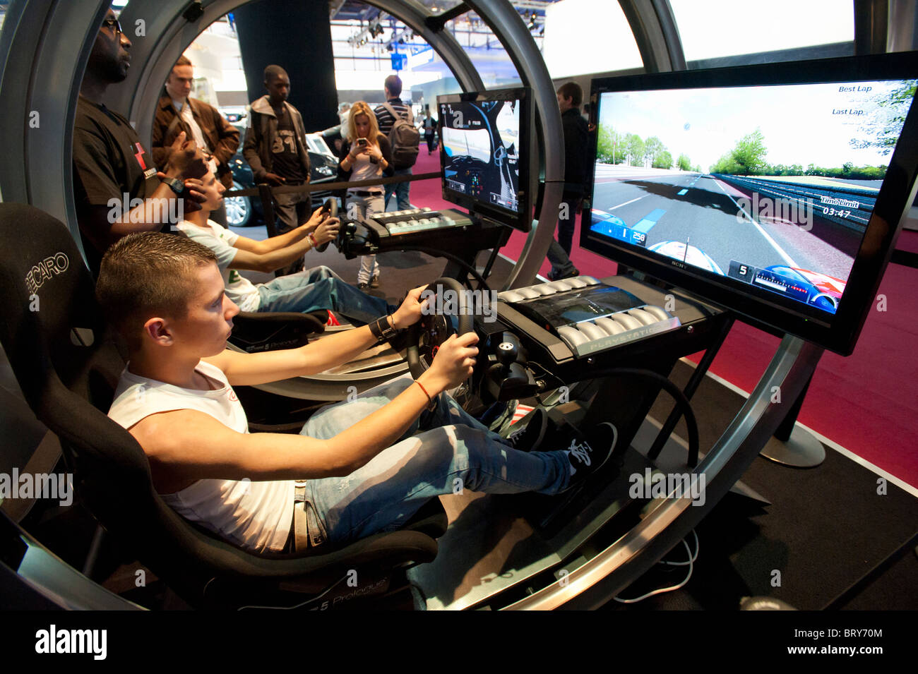 I visitatori che utilizzano Playstation simulatore di guida al Motor Show di Parigi 2010 Foto Stock