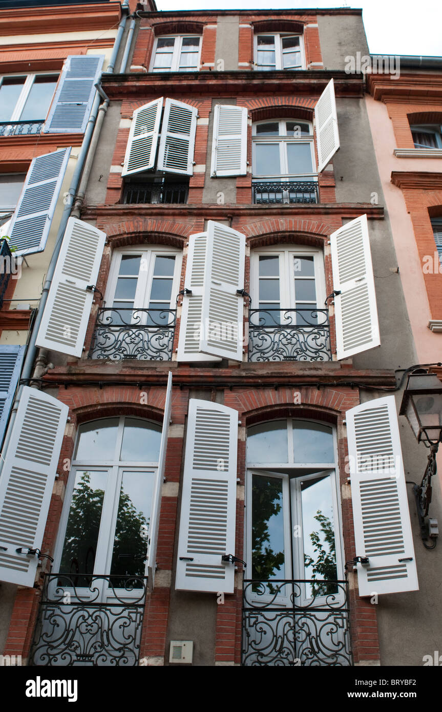 Bella rossa di case in mattoni con persiane bianche sul Croix-Baragnon street, Toulouse, Francia Foto Stock