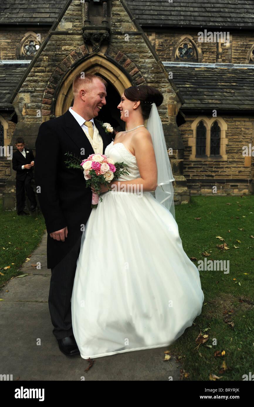 Sposa e lo sposo appena sposati al di fuori della chiesa Foto Stock