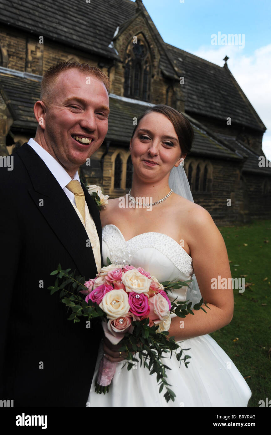 Sposa e lo sposo appena sposato sorridente verso la telecamera Foto Stock