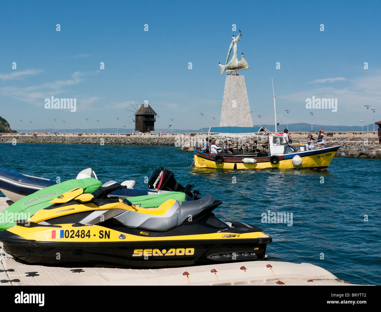 Barche in Nessebar Bay e il porto, Bulgaria, con la statua di San Nicola in background Foto Stock