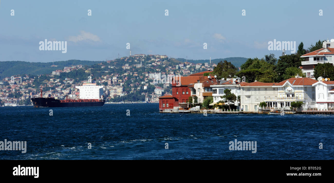 Waterfront homes in Kanlica sul Bosforo testimoniano il passaggio di una nave mercantile Foto Stock