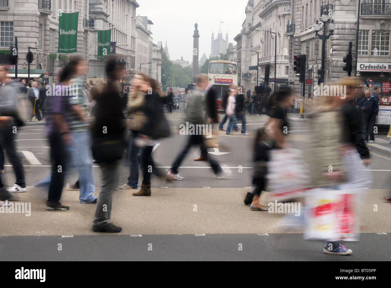 I pedoni a piedi attraverso un passaggio pedonale in Piccadilly Circus a Londra, Inghilterra Foto Stock