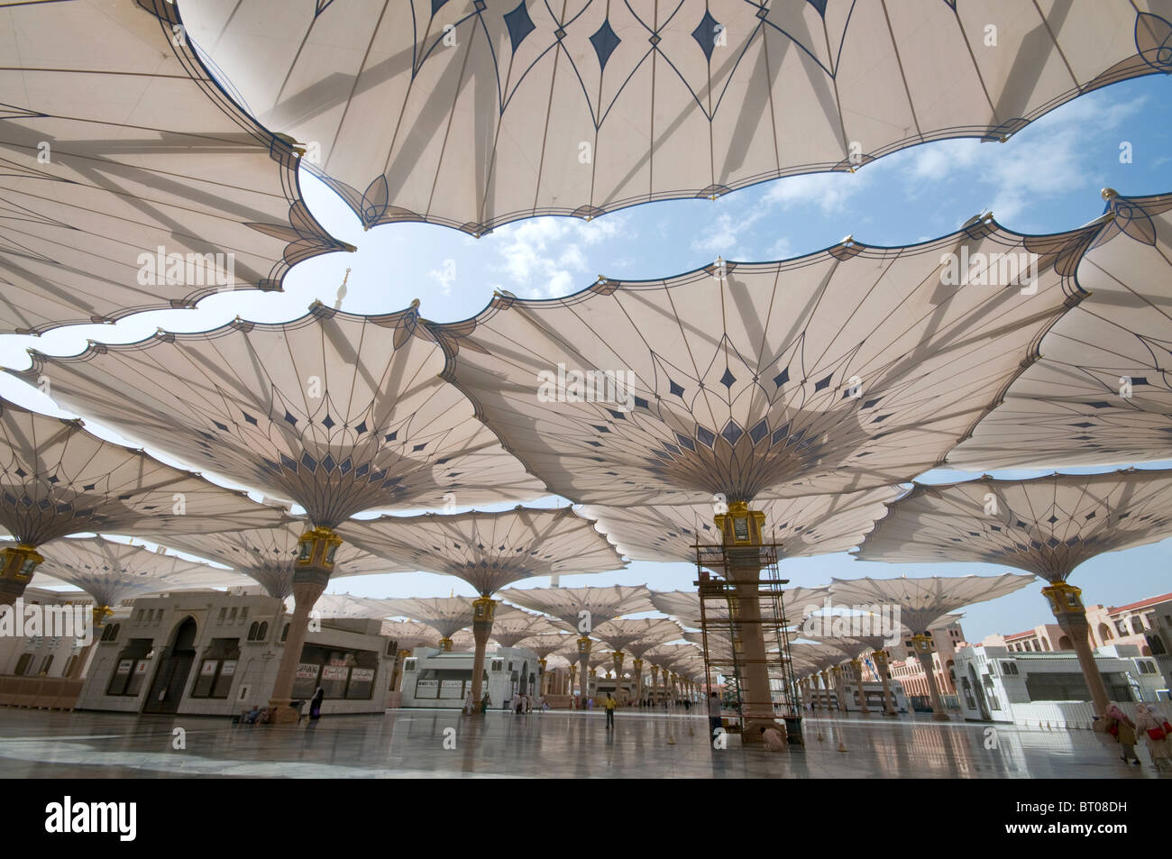 Pellegrini a piedi sotto ombrelloni giganti in moschea Nabawi composto il 22 aprile 2010 a Medina, Regno di Arabia Saudita Foto Stock