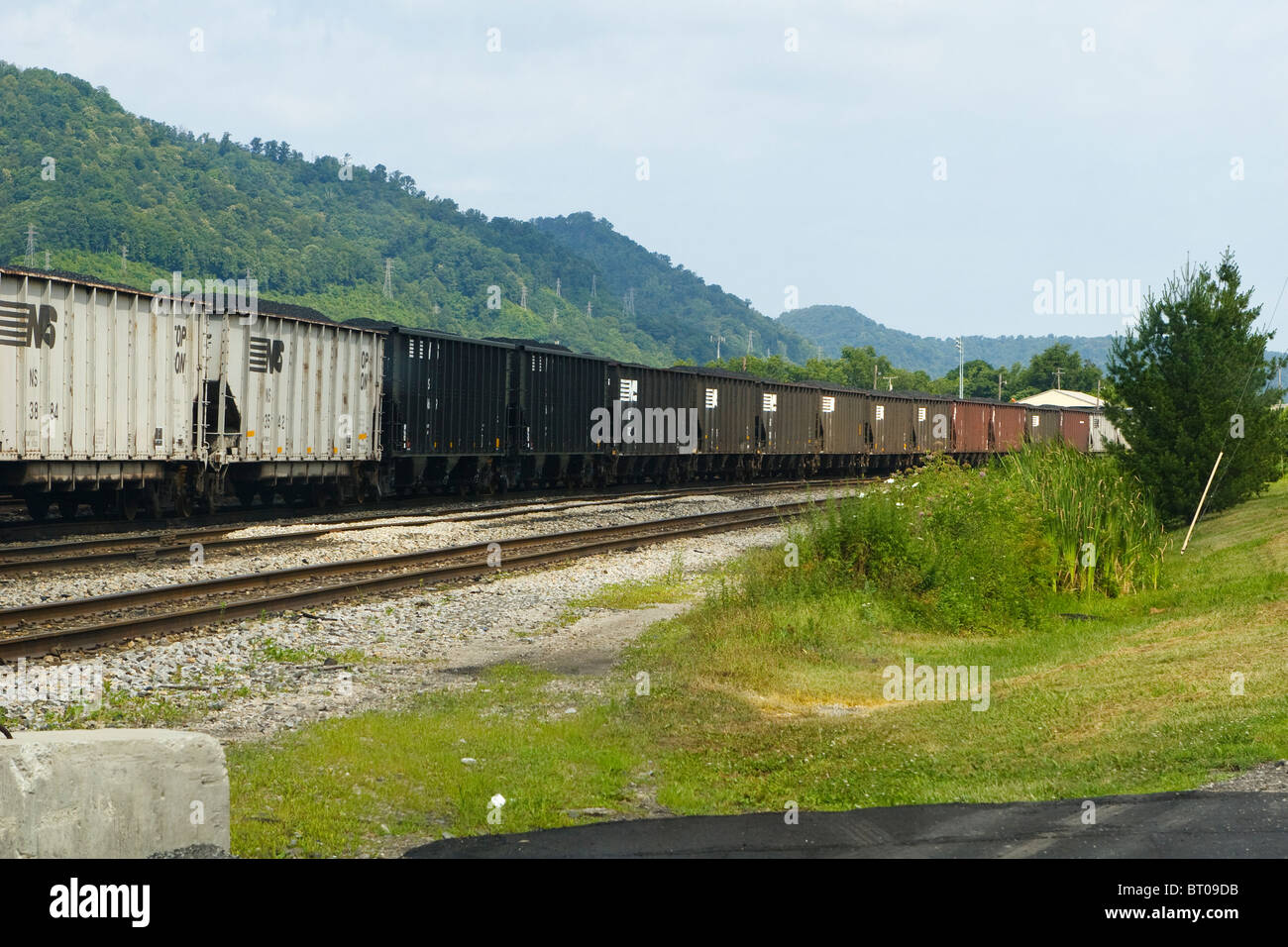 Una fila di Norfolk Southern vetture di carbone nella Dickinson cantiere ferroviario vicino a sud di Charleston, West Virginia su una cortina di nubi, giorno d'estate. Foto Stock