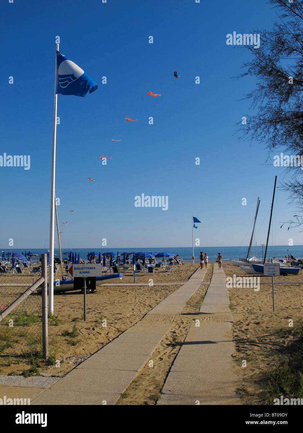 Percorso per le barche a vela lungo la spiaggia e una bandiera blu a Bibione Pineda, Veneto, Italia Foto Stock