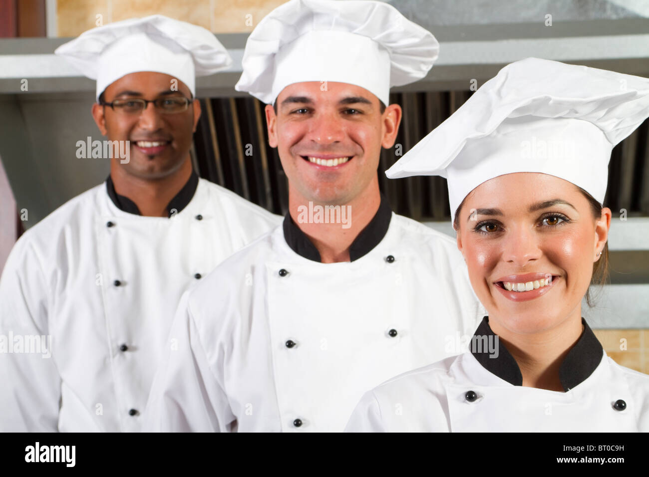 Un gruppo di giovani belle chef professionisti ritratto in cucina industriale Foto Stock