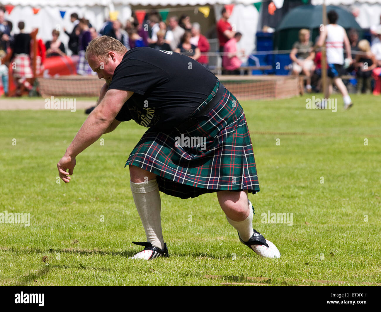 Concorrente esegue una pietra messo a Scottish Highland Games event Foto Stock