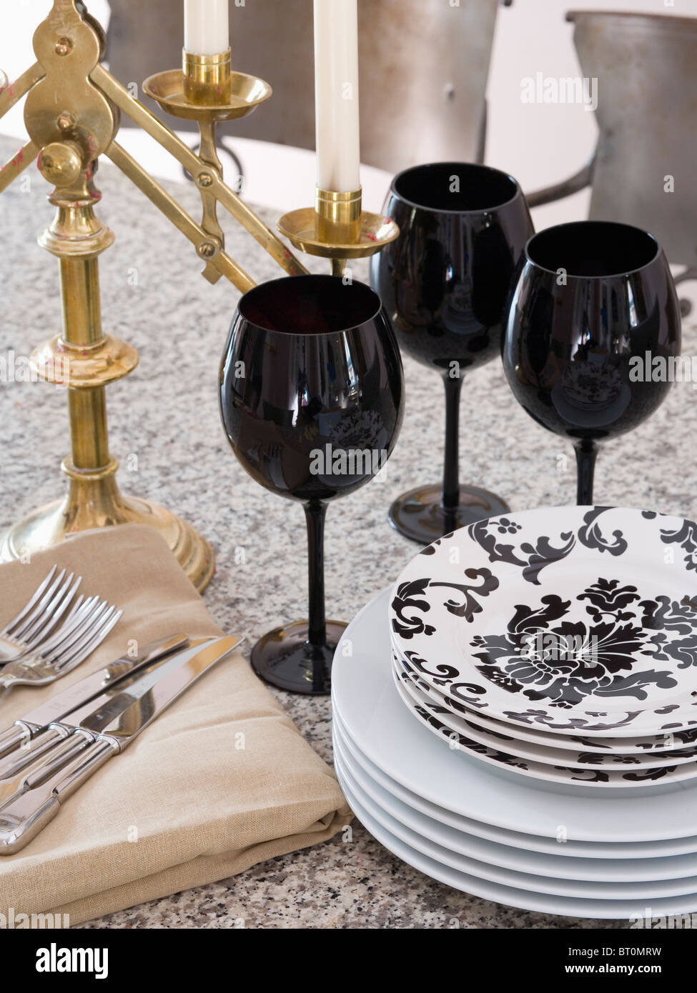 Close-up di grigio scuro-vino bicchieri sul tavolo con nero+bianco piastre modellato Foto Stock