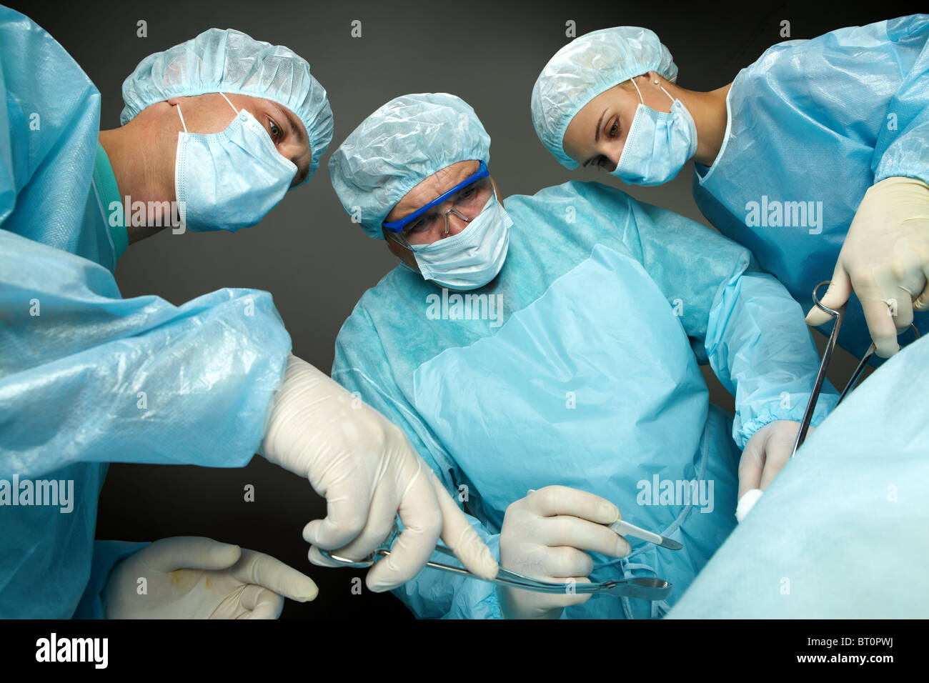 Vista dal basso del tre chirurghi operanti Foto Stock
