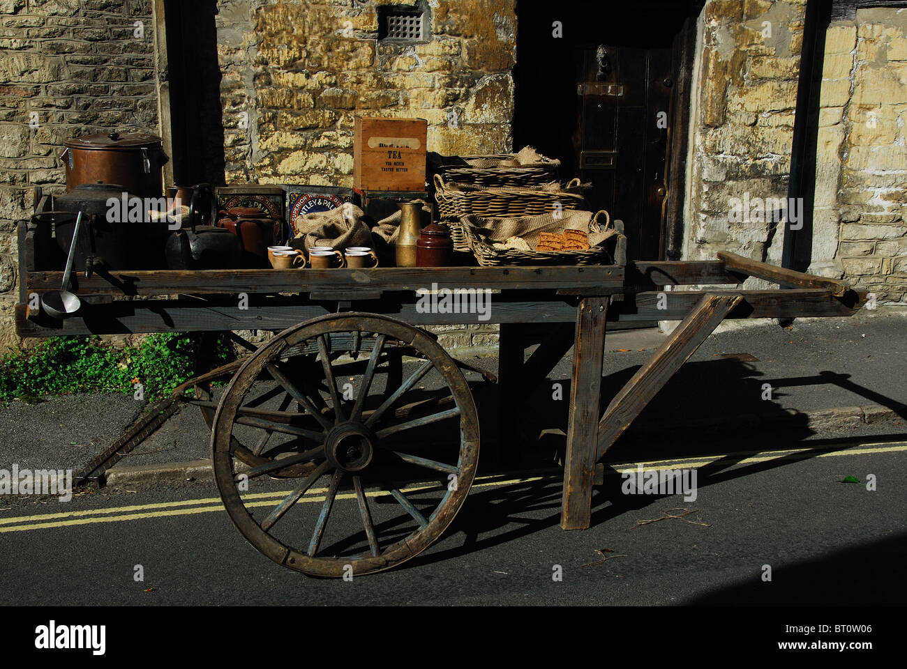 Un vecchio stile di stallo di mercato su ruote al bellissimo villaggio di Castle Combe, Wiltshire, preparando per le riprese Foto Stock