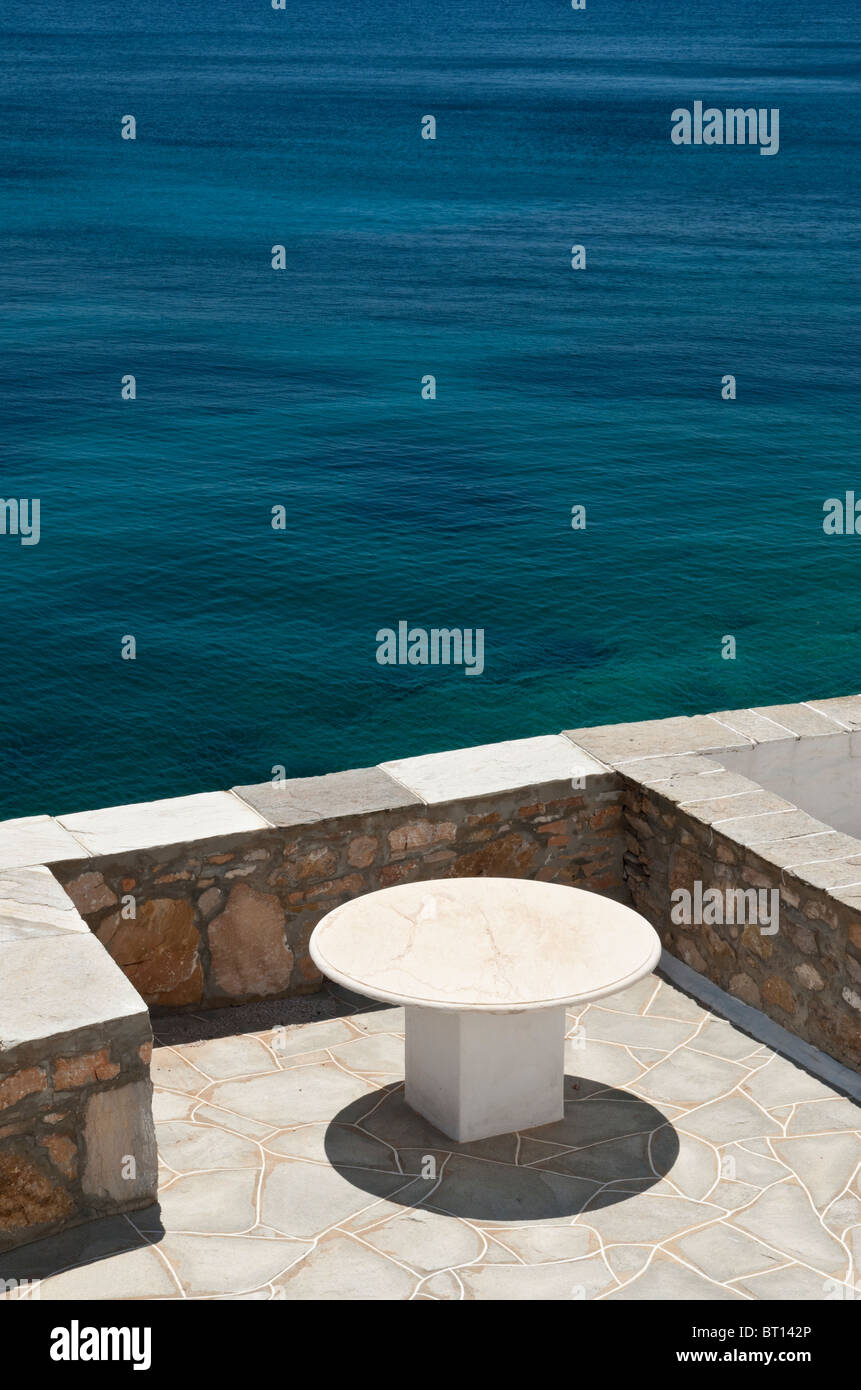 Svuotare round tavolo di pietra che si affaccia sul Mare Egeo, Sifnos, Grecia Foto Stock