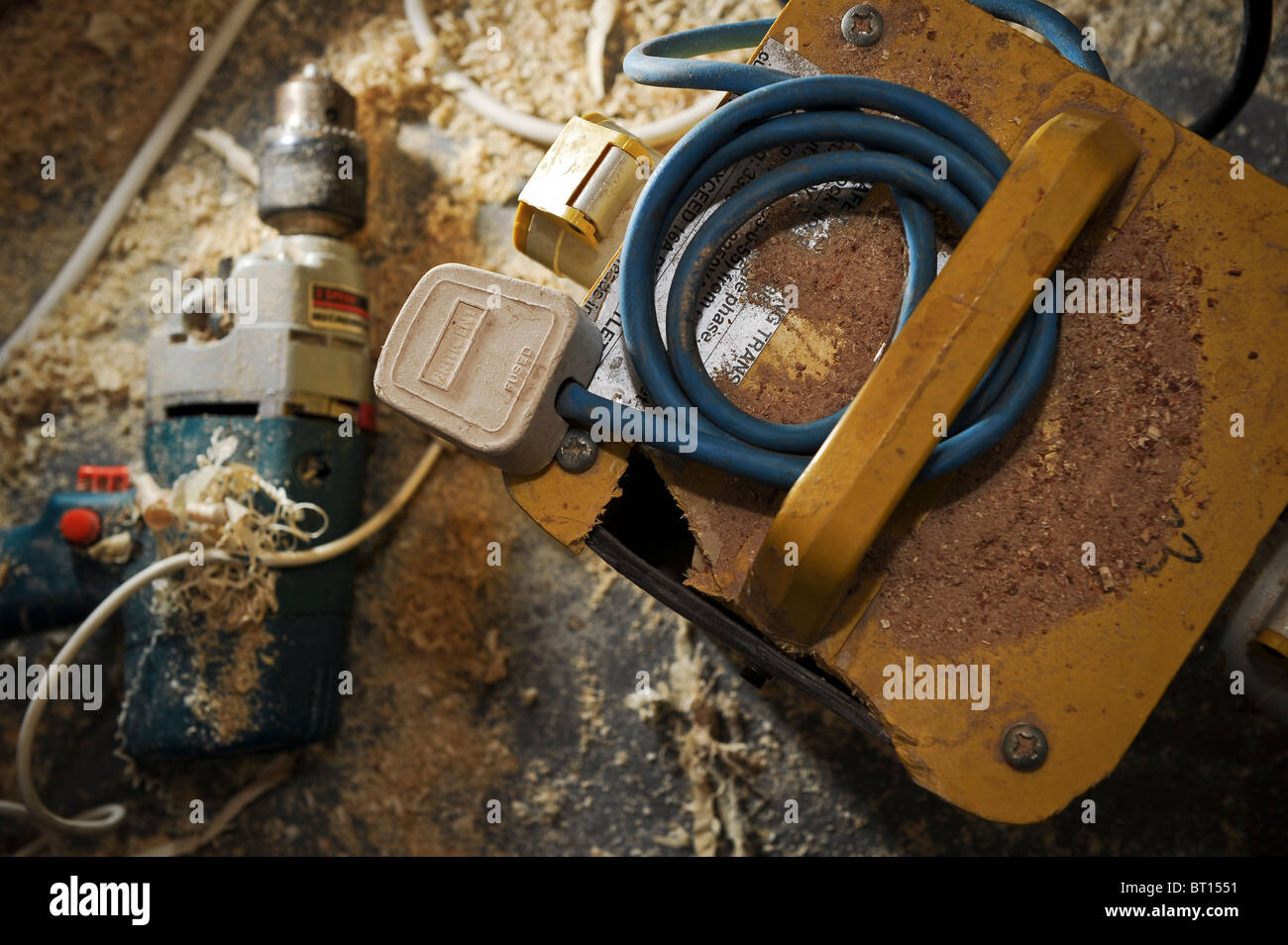 Pericoloso e confuso in officina con potenza non sicuri gli strumenti come un trapano danneggiato e il trasformatore che crea un rischio di incendio Foto Stock