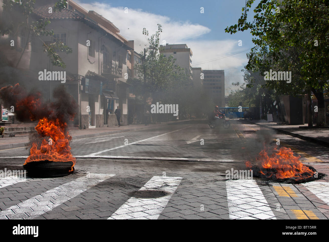 Copertoni bruciati come blocchi stradali a Quito, Ecuador, risultante da proteste da parte della polizia per pagare Foto Stock