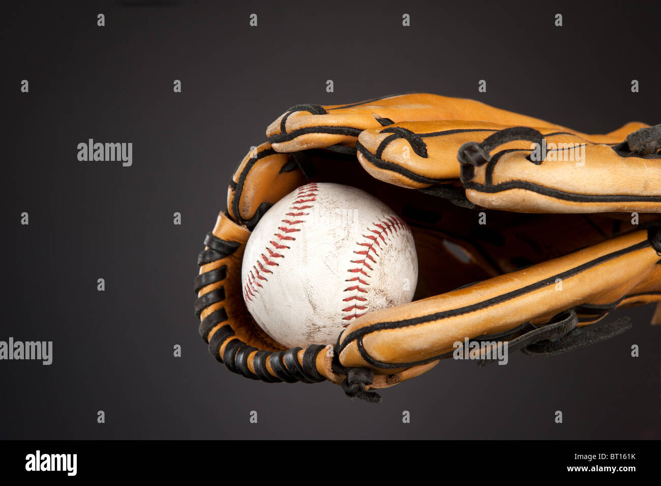 Una palla da baseball e Guanto baseball sport tema su un gradiente grigio, moody sfondo. Foto Stock