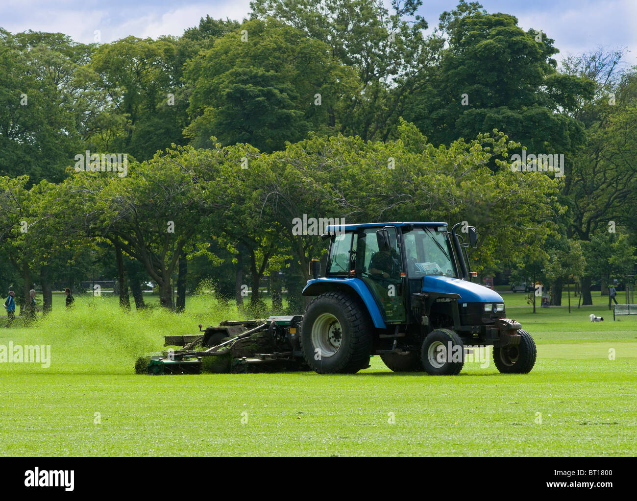 Un trattore taglia l'erba a Prato Ovest Park, Edimburgo Foto Stock
