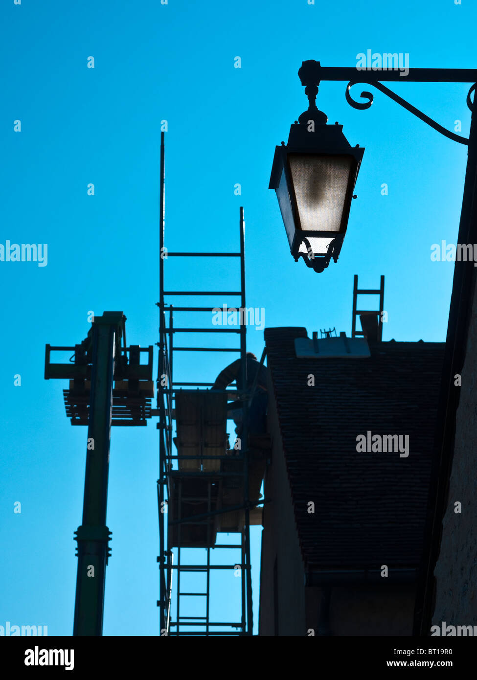 Gli appaltatori che lavorano per le riparazioni del tetto con Altrad ponteggio prefabbricato unità / nessuna attrezzatura di sicurezza - Francia. Foto Stock