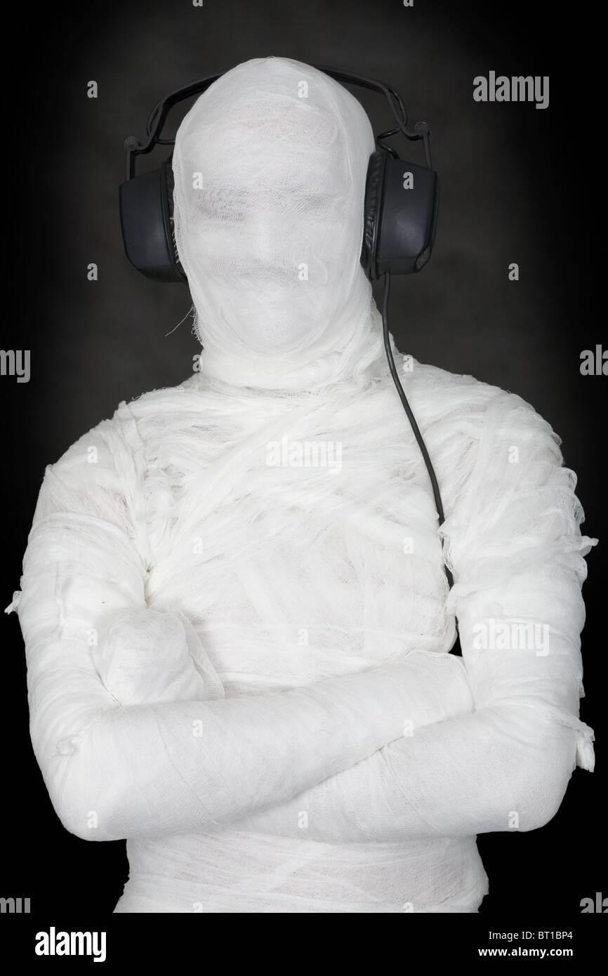 Mummia in ear-telefoni su sfondo nero Foto Stock