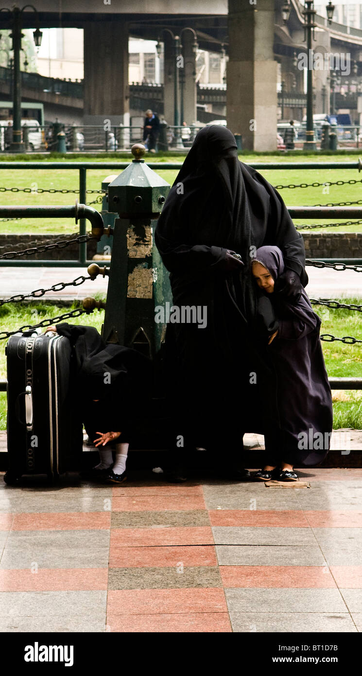 Una famiglia musulmana vestita di nero e Jalabia Hijabs. La madre indossa un velo. Foto Stock