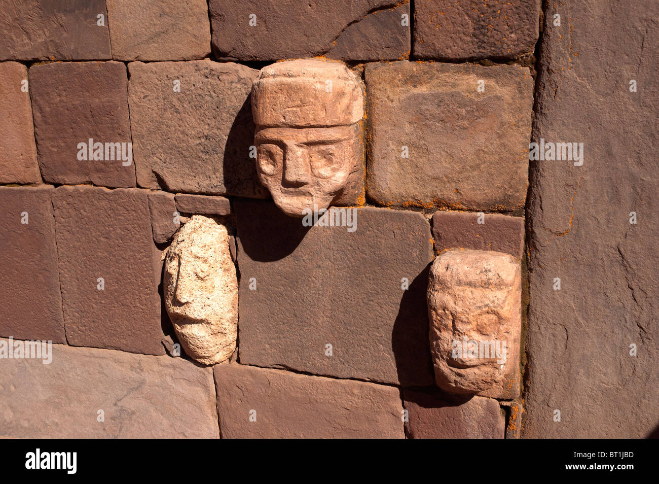 Teste scolpite e le facce nel Templete Semisubterraneo, a Tiwanaku sito archeologico, un pre civilizzazione Inca, in Bolivia. Foto Stock