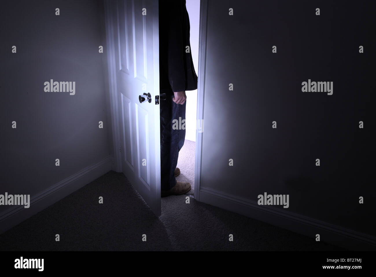 Uomo in piedi al di fuori di un ambiente buio Foto Stock