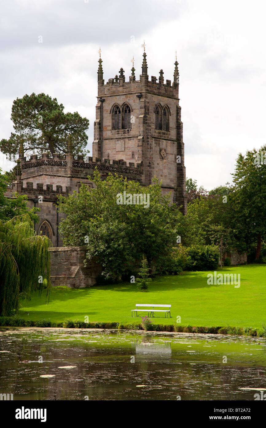 Un tradizionale inglese chiesa gotica in una tenuta di campagna da un lago. Foto Stock