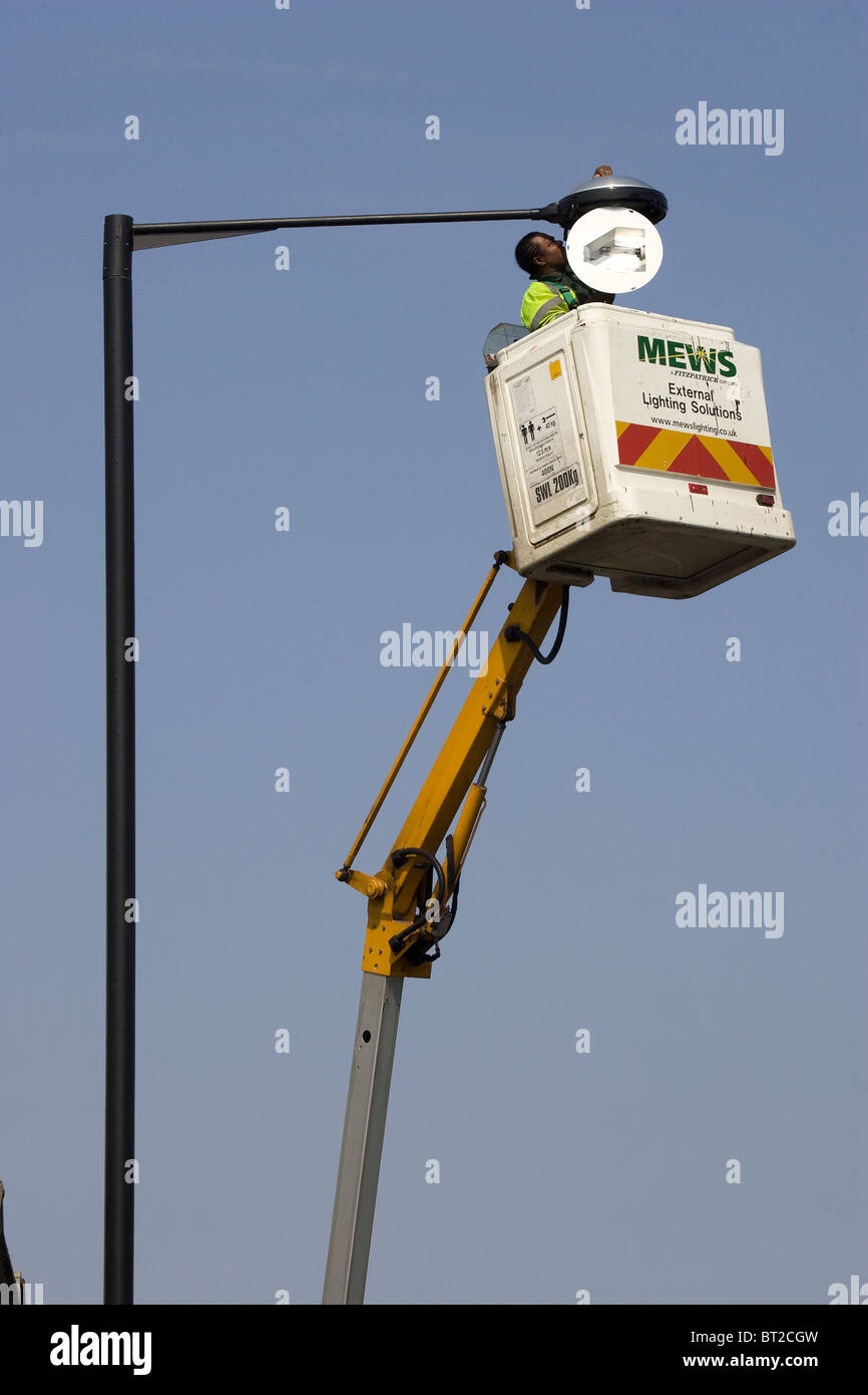 La riparazione di una lampadina sulla cima di un lampione Foto Stock