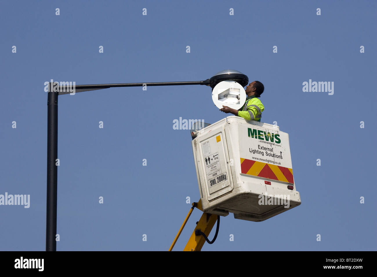 La riparazione di una lampadina sulla cima di un lampione Foto Stock