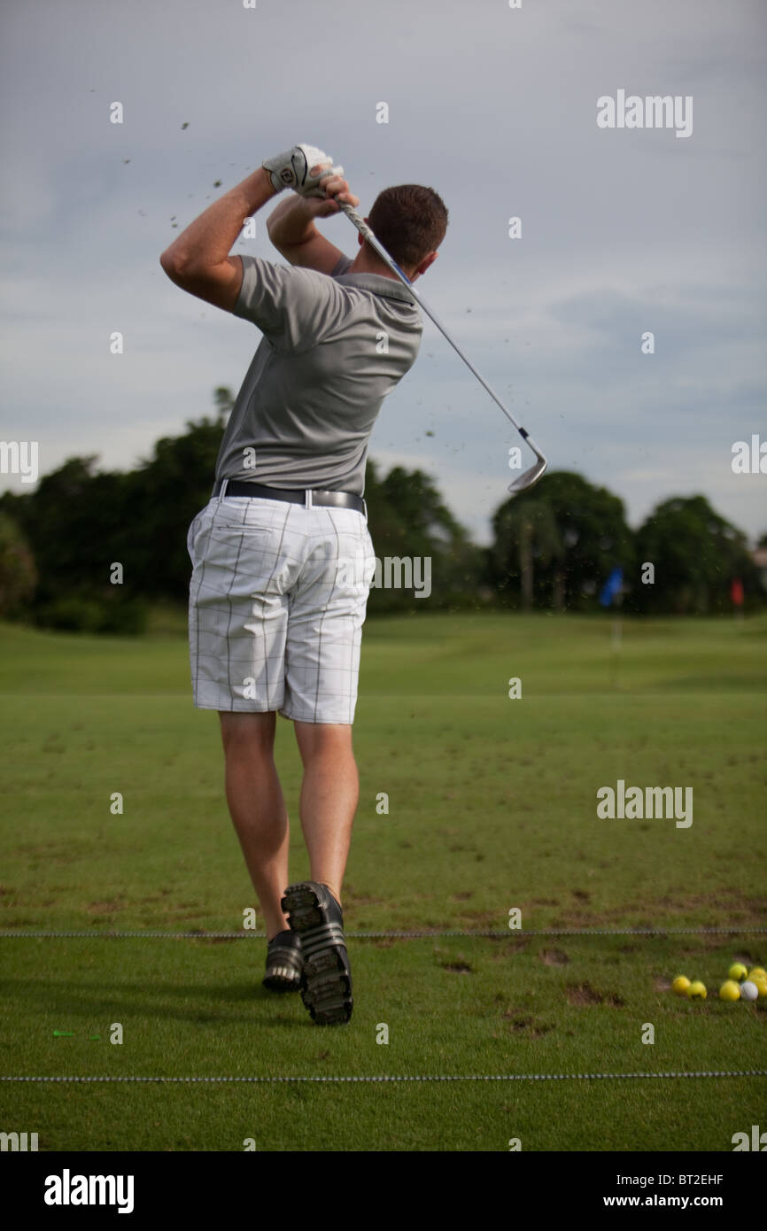 Golfista maschio guida, colpo da dietro. Foto Stock