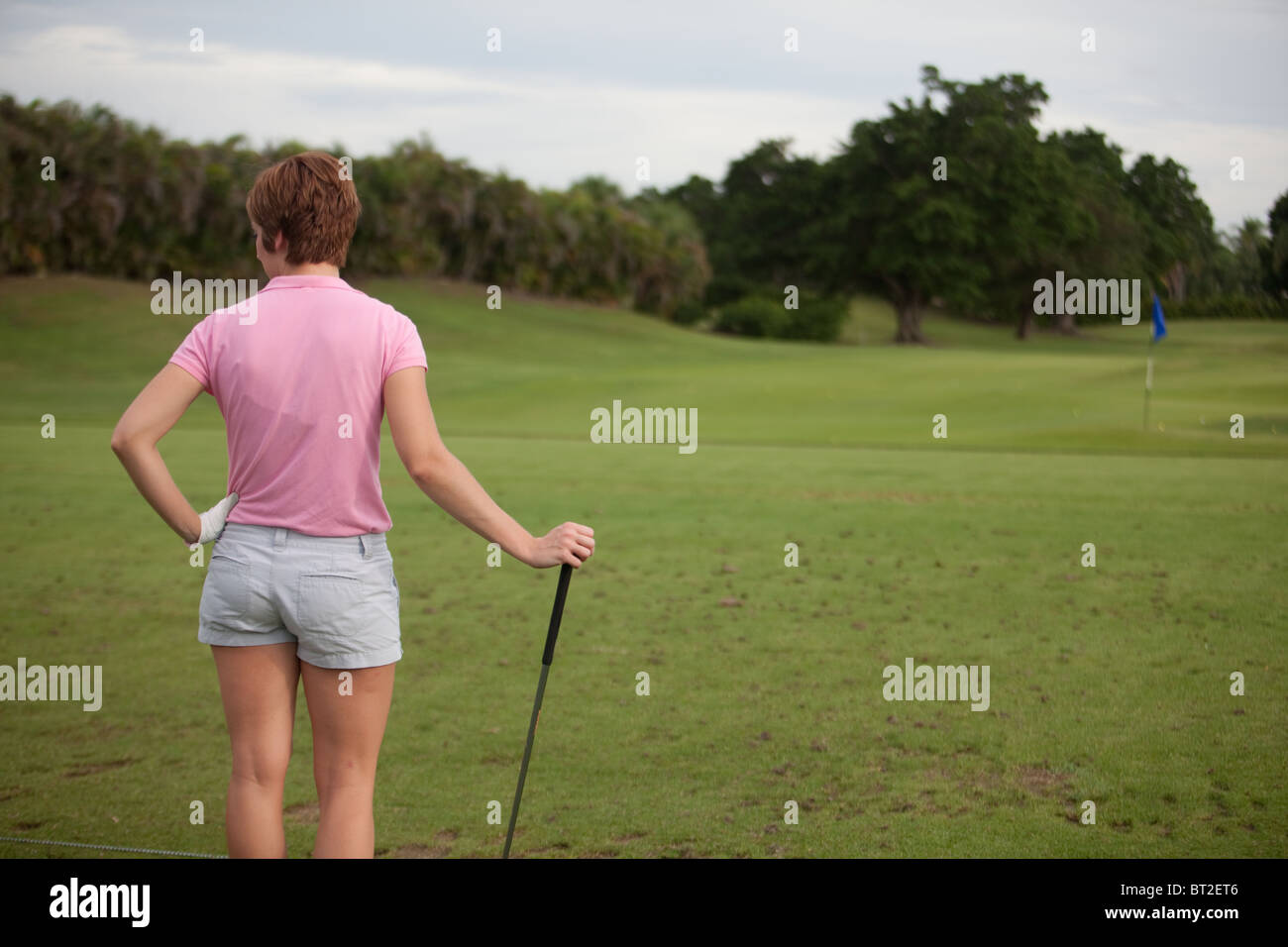 Giocatore di golf femminile guarda verso il corso Foto Stock