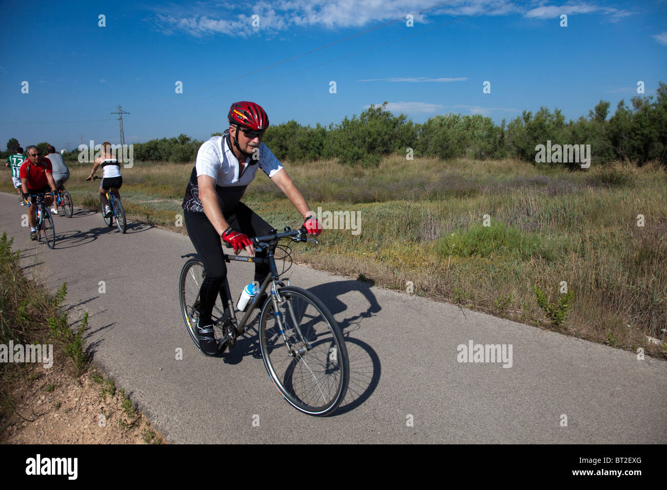 Persone in bicicletta attraverso il Parc Natural dels Aiguamolls de l'Emporda Emporda Catalunya Spagna Foto Stock