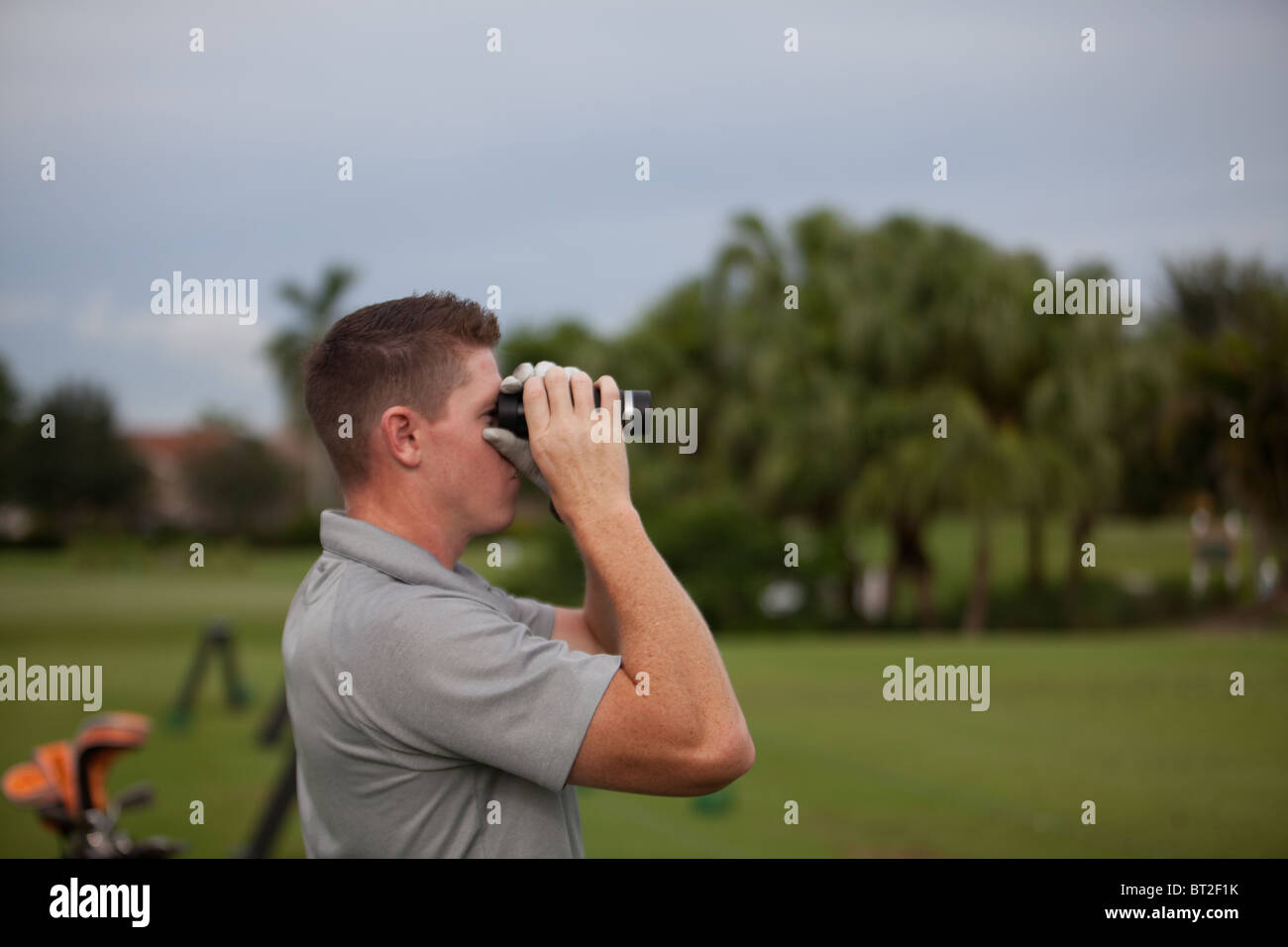 Il Golfer utilizza una speciale binocoli per il rilevamento della distanza. Foto Stock